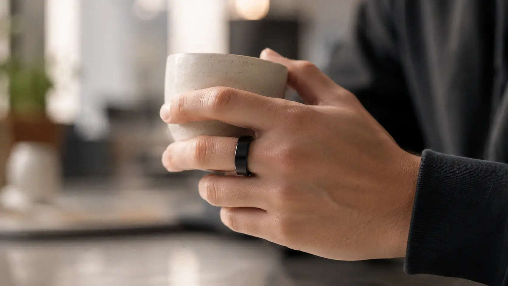 Smart ring worn naturally while holding a coffee cup during everyday activities